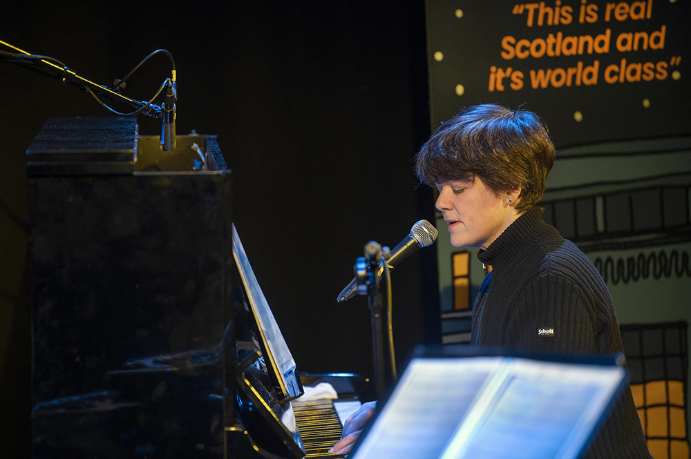 a person sings into a microphone with sheet music in the foreground