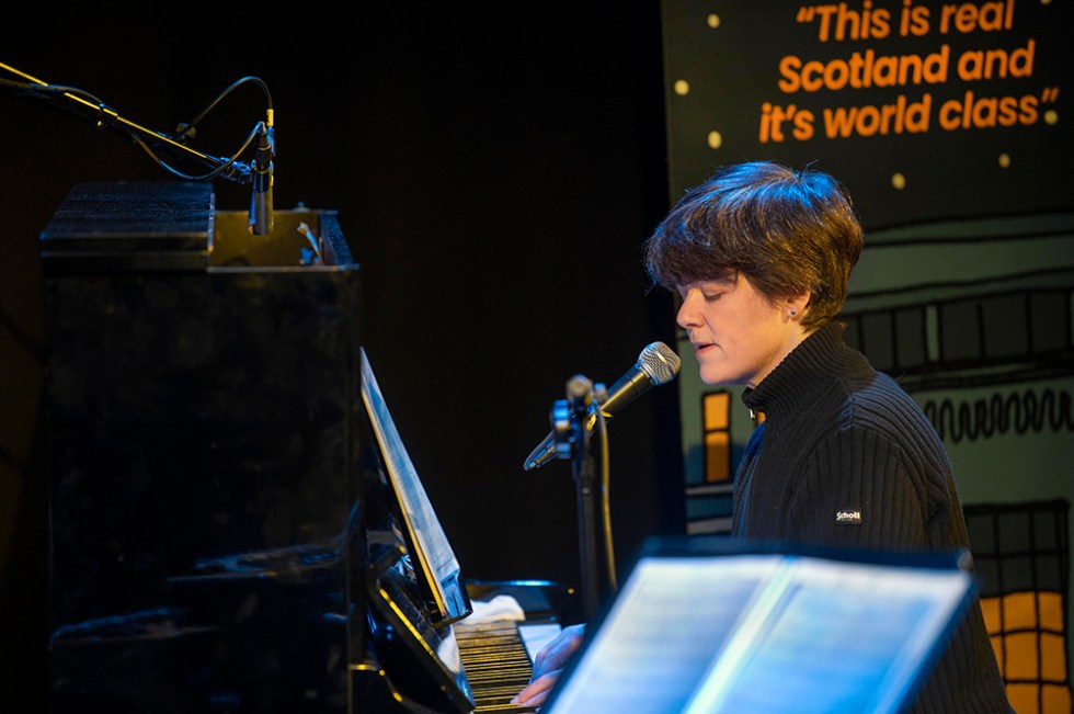 a person sings into a microphone with sheet music in the foreground